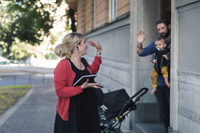 Mid adult mother waving family while leaving for work