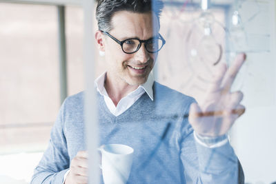 Businessman touching transparant projection screen in office