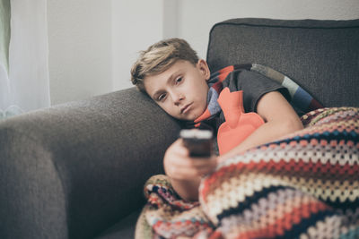 Portrait of boy lying on sofa at home