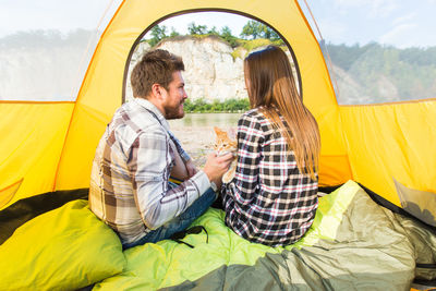 Young couple sitting in tent