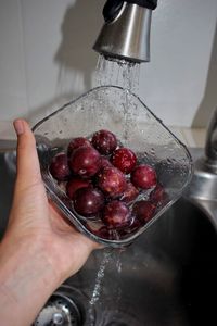 Midsection of person holding strawberry in water