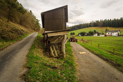 Road amidst field against sky