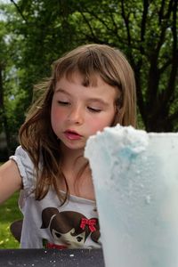 Close-up of cute girl with drink on table outdoors