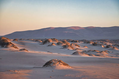 Scenic view of desert against sky during sunset