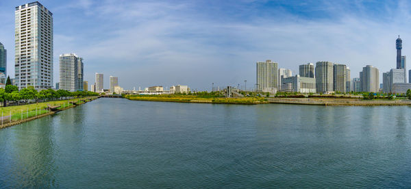 River by buildings against sky in city