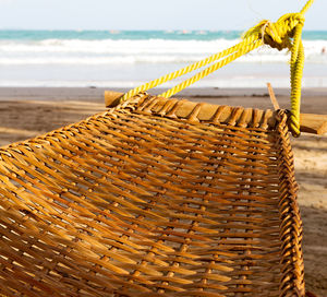 Close-up of wicker basket on beach