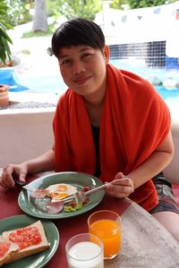 Portrait of smiling woman having breakfast on table