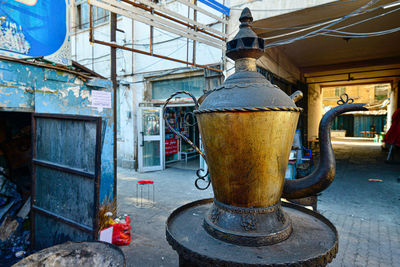 A trash dump and oversized uyghur teapot landmark inside a traditional market