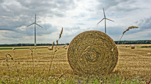 Hay bales on field against sky