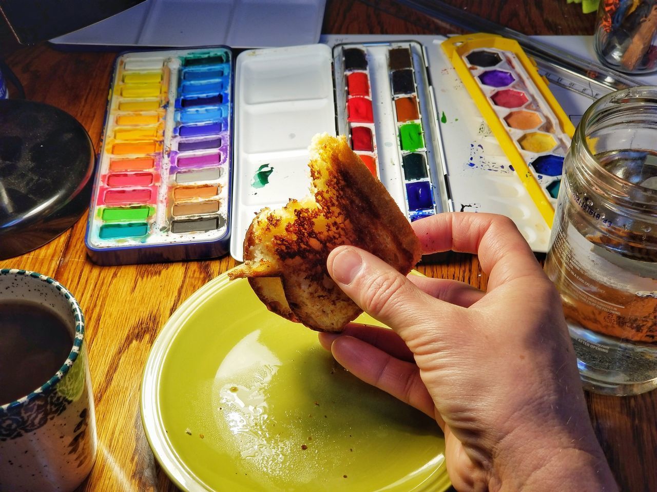 CLOSE-UP OF HAND HOLDING DRINK IN PLATE