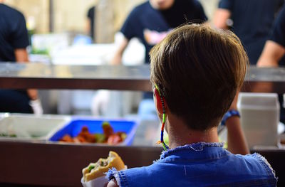 Rear view of a boy sitting outdoors