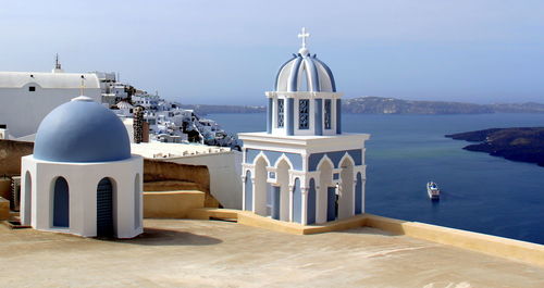 View of temple by sea against sky