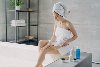 Portrait of young woman sitting in bathroom