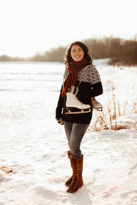 Woman in warm clothing standing on snow