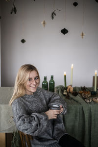 Portrait of young woman sitting on sofa at home