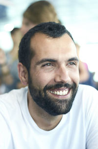 Close-up of smiling bearded man looking away