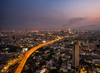 High angle view of illuminated cityscape against sky at night