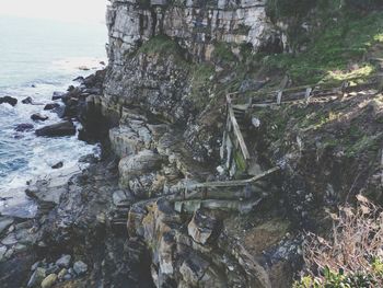 Moss on rock by sea against sky