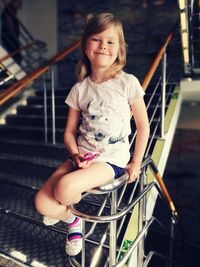 Portrait of cute girl sitting on staircase