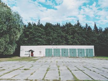 House amidst trees and plants against sky