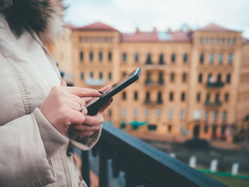 Midsection of woman using mobile phone