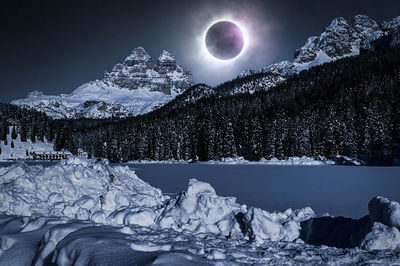 Scenic view of snowcapped mountains against sky at night