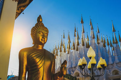 Statue against temple building against sky