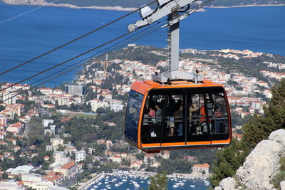 Overhead cable car in city against sky