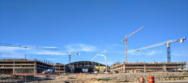 Cranes at construction site against sky