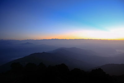 Scenic view of silhouette mountains against sky during sunrise