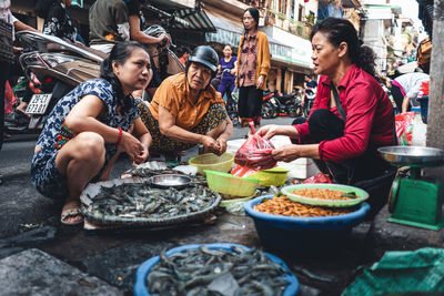 People sitting at market stall