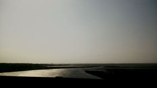 Road by sea against clear sky