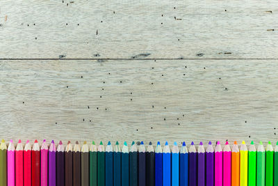 Directly above shot of colored pencils on wooden table