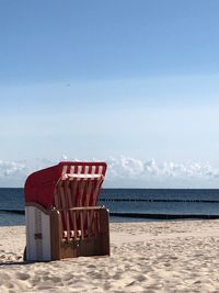 Chair on beach against sky