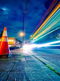 Light trails on road against sky at night