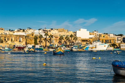 Sailboats in sea against buildings in city