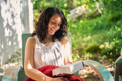 Young woman looking away while sitting outdoors