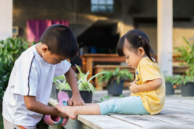 Rear view of siblings sitting outdoors