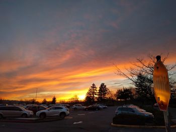 Cars on road against sky during sunset