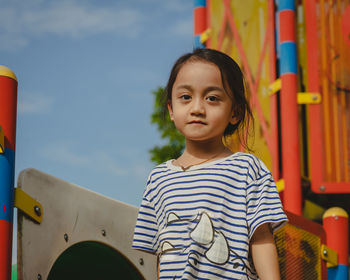 Portrait of a little girl with cute face sitting and looking away.