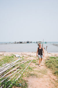 Woman standing on beach against clear sky