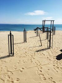 Deck chairs on beach against sky