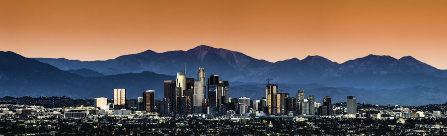 Panoramic view of buildings in city against sky during sunset