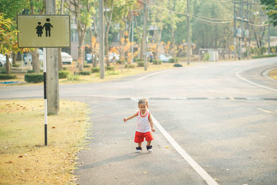 Boy walking on road in city