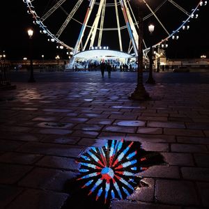 Low angle view of illuminated ferris wheel at night