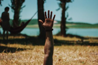 Midsection of person hand on field