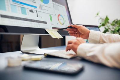 Woman entrepreneur working with data on charts on computer. woman sitting at desk in office. desktop