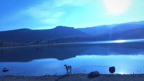 Scenic view of lake by mountains against sky