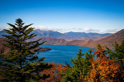 Scenic view of lake chuzenji and mountains against blue sky