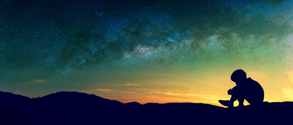 Silhouette of man against sky at night
